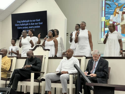 The praise team leading worship in white